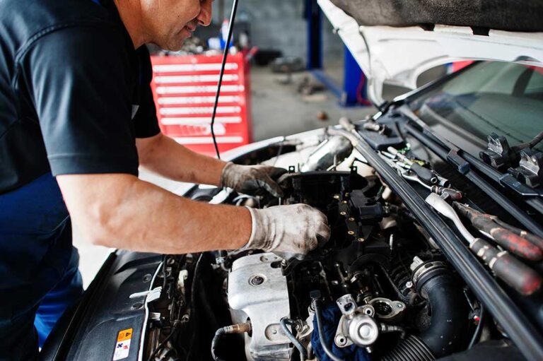 A person polishing a cloudy plastic headlight lens beside a parked vehicle